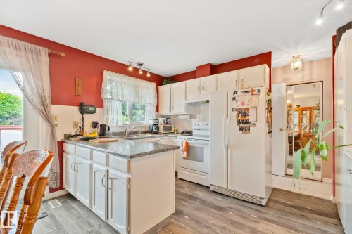 Kitchen featuring white cabinetry, gray granite-style countertops, and wood-finish flooring - 30 Garden Valley Drive, Stony Plain, AB - Indoor Photo Showing Kitchen