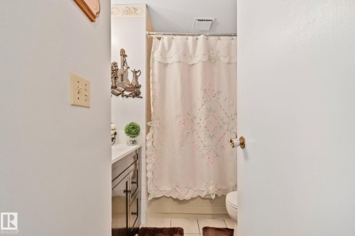 Bathroom featuring a vanity with dark wood-finish cabinetry, a white countertop, and a shower/tub combination - 30 Garden Valley Drive, Stony Plain, AB - Indoor Photo Showing Bathroom