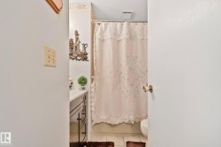 Bathroom featuring a vanity with dark wood-finish cabinetry, a white countertop, and a shower/tub combination - 