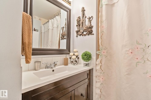Vanity with dark wood cabinetry, white countertop, and integrated sink - 30 Garden Valley Drive, Stony Plain, AB - Indoor Photo Showing Bathroom
