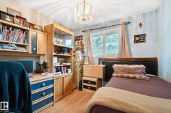 Room featuring wood-finish flooring, a double-paned window, and a decorative ceiling light fixture - 