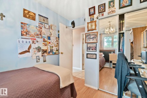 Bedroom featuring light blue walls, wood-finish flooring, and a mirrored closet with sliding doors - 30 Garden Valley Drive, Stony Plain, AB - Indoor Photo Showing Bedroom