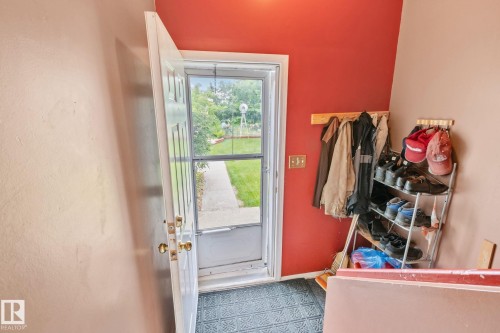 Entryway featuring a white paneled door with brass hardware, patterned floor tiling, and a contrasting accent wall - 30 Garden Valley Drive, Stony Plain, AB - Indoor