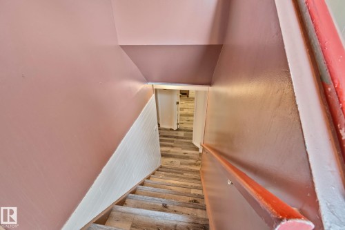 Staircase featuring wood-finish treads, a contrasting white and pink wall design, and a wooden handrail - 30 Garden Valley Drive, Stony Plain, AB - Indoor Photo Showing Other Room