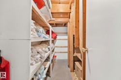 Unfinished basement area featuring exposed wood framing, concrete flooring, and built-in shelving - 