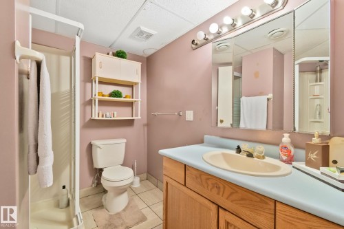 Bathroom featuring a single vanity with an integrated sink, a large wall-mounted mirror, and overhead strip lighting - 30 Garden Valley Drive, Stony Plain, AB - Indoor Photo Showing Bathroom