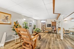Spacious interior featuring wood-finish flooring, a drop ceiling, and light wall paint - 
