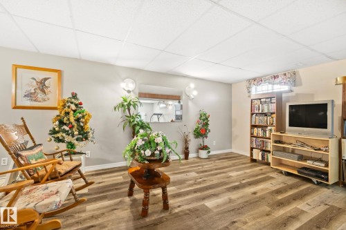 Spacious room featuring wood-finish flooring, light grey walls, and a white acoustical tile ceiling - 30 Garden Valley Drive, Stony Plain, AB - Indoor