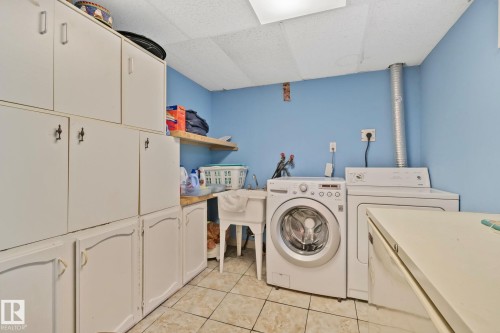 Dedicated utility space featuring extensive white cabinetry, a built-in utility sink, and tile flooring - 30 Garden Valley Drive, Stony Plain, AB - Indoor Photo Showing Laundry Room