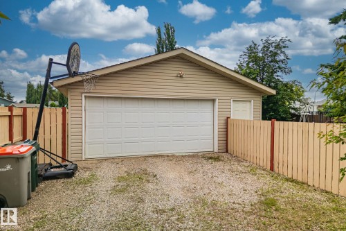 Detached garage with horizontal vinyl siding and a white sectional garage door - 30 Garden Valley Drive, Stony Plain, AB - Outdoor