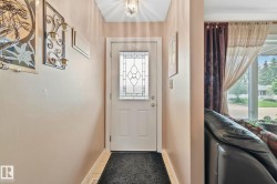 Entryway featuring a white door with decorative glass inserts, ceramic tile flooring, and a ceiling-mounted light fixture - 