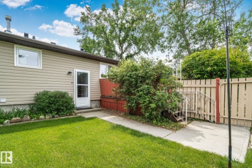 Rear exterior featuring tan horizontal siding and a white door with a glass panel - 30 Garden Valley Drive, Stony Plain, AB - Outdoor