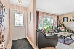 Foyer with a leaded glass entry door, overhead light fixture, and tile flooring - 