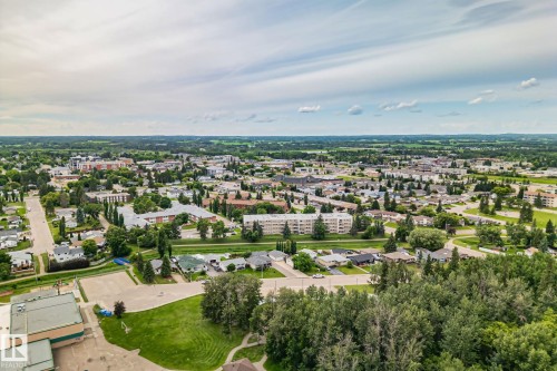 Expansive aerial perspective showcasing a community with diverse residential architecture, mature tree-lined streets, and open green spaces - 30 Garden Valley Drive, Stony Plain, AB - Outdoor With View