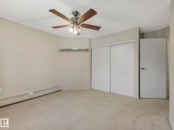 Neutral-toned room featuring a ceiling fan with integrated lighting, textured ceiling, and light-colored carpeting - 