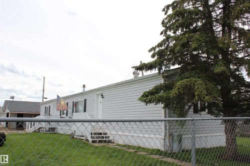 White siding exterior with multiple windows featuring black shutters - 4839 49 Avenue, Chipman, AB 