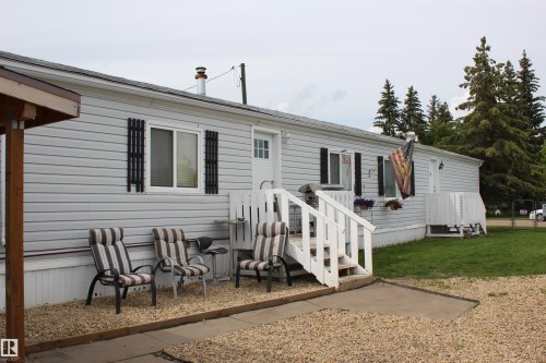Single-story residence featuring light gray siding with white trim and black decorative window shutters - 4839 49 Avenue, Chipman, AB 