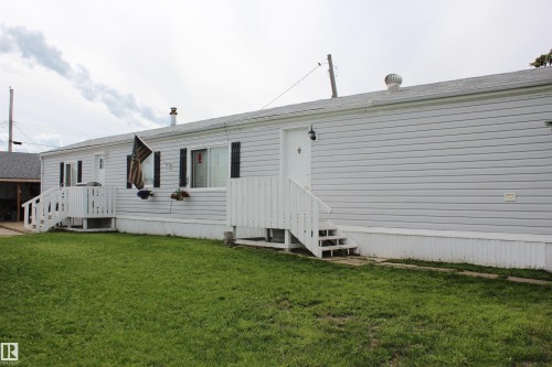 Exterior featuring white horizontal siding, a gabled roofline, and two separate white entry doors with matching white railings - 4839 49 Avenue, Chipman, AB 