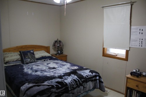 Bedroom featuring a wood-finish bed frame and an overhead ceiling fan - 4839 49 Avenue, Chipman, AB 
