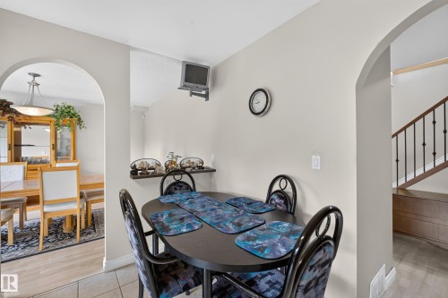 Dining area featuring two arched doorways, a built-in shelf, and neutral wall tones - 3841 62 Street, Edmonton, AB 