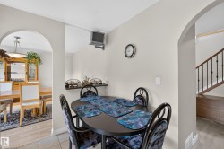 Dining area featuring two arched doorways, a built-in shelf, and neutral wall tones - 