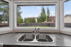 Kitchen sink area featuring a dual-basin stainless steel sink with an integrated faucet - 