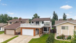 Split-level residence featuring a prominent upper-level deck with white railings - 