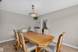 Dining area featuring wood-finish flooring, light gray wall paint, and white baseboards - 