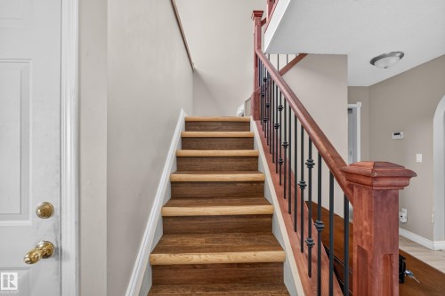 Wood-finish staircase featuring light risers and darker treads - 3841 62 Street, Edmonton, AB 