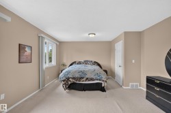 Expansive room featuring neutral wall tones, plush carpet flooring, a window offering natural illumination, a built-in closet, and a ceiling-mounted light fixture - 