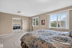 Carpeted room with a ceiling-mounted light fixture, two white-framed windows, and mirrored closet doors - 