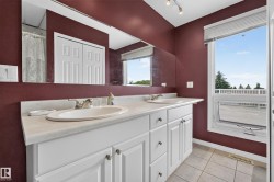 Double vanity featuring white cabinetry and light-toned countertops - 
