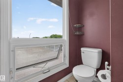 White casement window with an open screen, showcasing a large exterior patio area - 