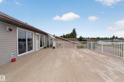 Expansive outdoor deck featuring a concrete surface and white perimeter railing - 