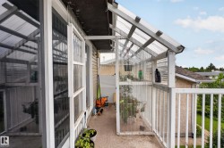 Balcony featuring a built-in greenhouse structure with translucent corrugated panels and a white railing - 