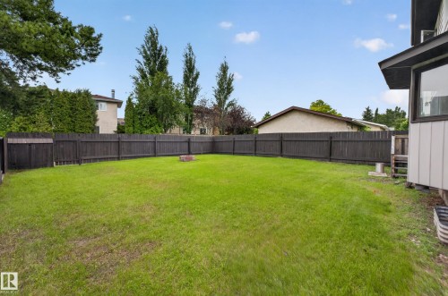 Expansive backyard with a manicured lawn, full perimeter privacy fence, and mature trees - 3841 62 Street, Edmonton, AB 