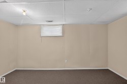 Finished room with neutral-toned walls, brown carpeting, and a drop ceiling - 
