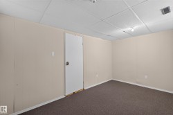 Carpeted room featuring light-colored panel walls and a drop ceiling - 