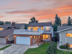 Two-story residence featuring a large upper-level deck with white railings, a sunroom with glass paneled walls, and an integrated garage with a white door - 