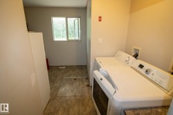 Dedicated laundry area featuring a white washing machine and dryer, a window with exterior views, and neutral wall tones - 