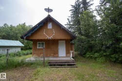 Cabin-style residence featuring a prominent gable roofline and a front porch - 