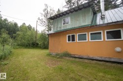 Two-story structure featuring an orange lower exterior and a green upper exterior - 