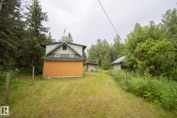 Structure featuring a two-story design with a green gabled roof and orange siding - 