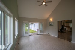 Spacious room with vaulted ceilings and a ceiling fan - 