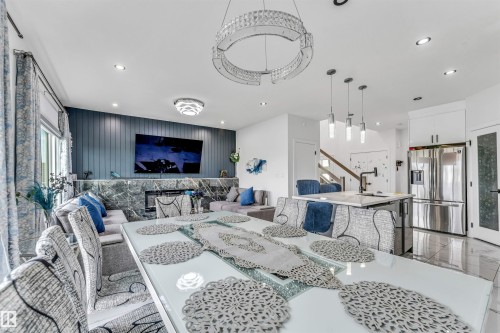 Open-concept main living area with recessed lighting, a modern chandelier, and a wood-finish accent wall - 5809 65 Street, Beaumont, AB - Indoor Photo Showing Other Room