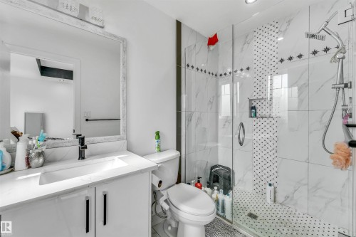 White vanity with black hardware and a quartz countertop - 5809 65 Street, Beaumont, AB - Indoor Photo Showing Bathroom