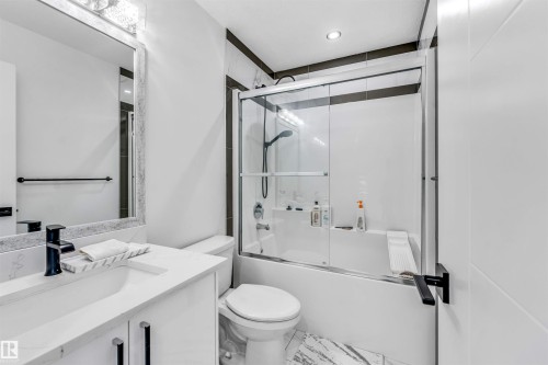 Bathroom featuring a white vanity with an integrated sink, matte black faucet, and a large framed mirror - 5809 65 Street, Beaumont, AB - Indoor Photo Showing Bathroom