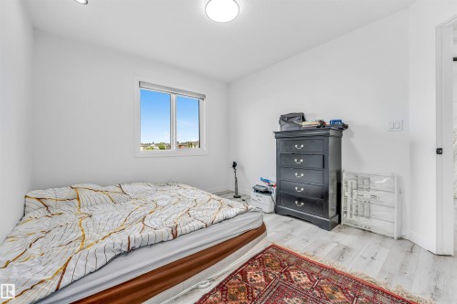 Bright room with light-toned wood-finish flooring, white walls, and a window providing natural illumination - 5809 65 Street, Beaumont, AB - Indoor Photo Showing Bedroom