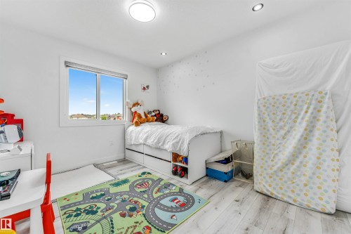 Bright room featuring wood-finish flooring, a double window, and recessed lighting - 5809 65 Street, Beaumont, AB - Indoor Photo Showing Bedroom