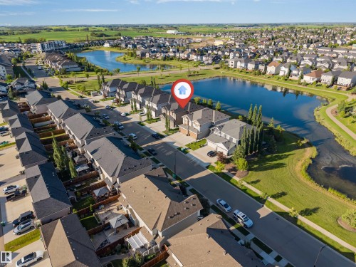 Residential neighborhood with a prominent body of water, featuring a mix of detached and attached homes - 5809 65 Street, Beaumont, AB - Outdoor With Body Of Water With View